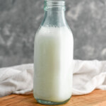 Glass bottle of Homemade Buttermilk sitting on a wooden board