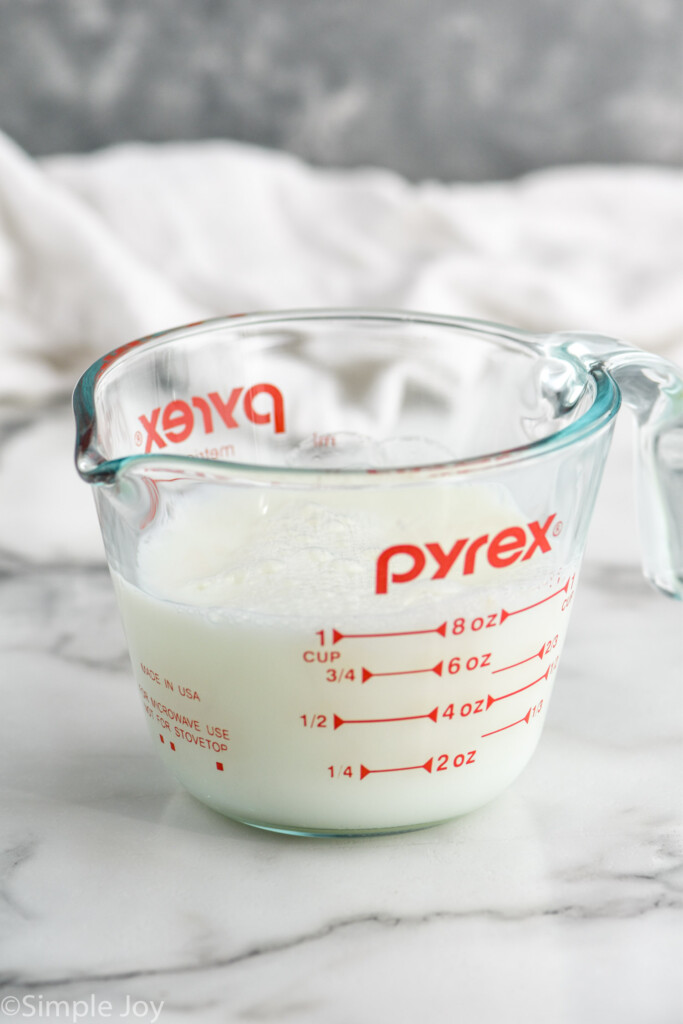 Glass measuring cup of milk and vinegar to make Homemade Buttermilk