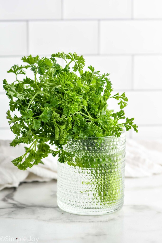 fresh parsley in a drinking glass with water to show How to Store Parsley