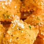 Pinterest graphic for Fried Ravioli. Says "the best Fried Ravioli simplejoy.com" Image shows closeup of Fried Ravioli with grated parmesan cheese.