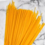 Pinterest graphic for How to Cook Pasta. Text says "How to Cook Pasta simplejoy.com" Image shows dry spaghetti sitting on the counter