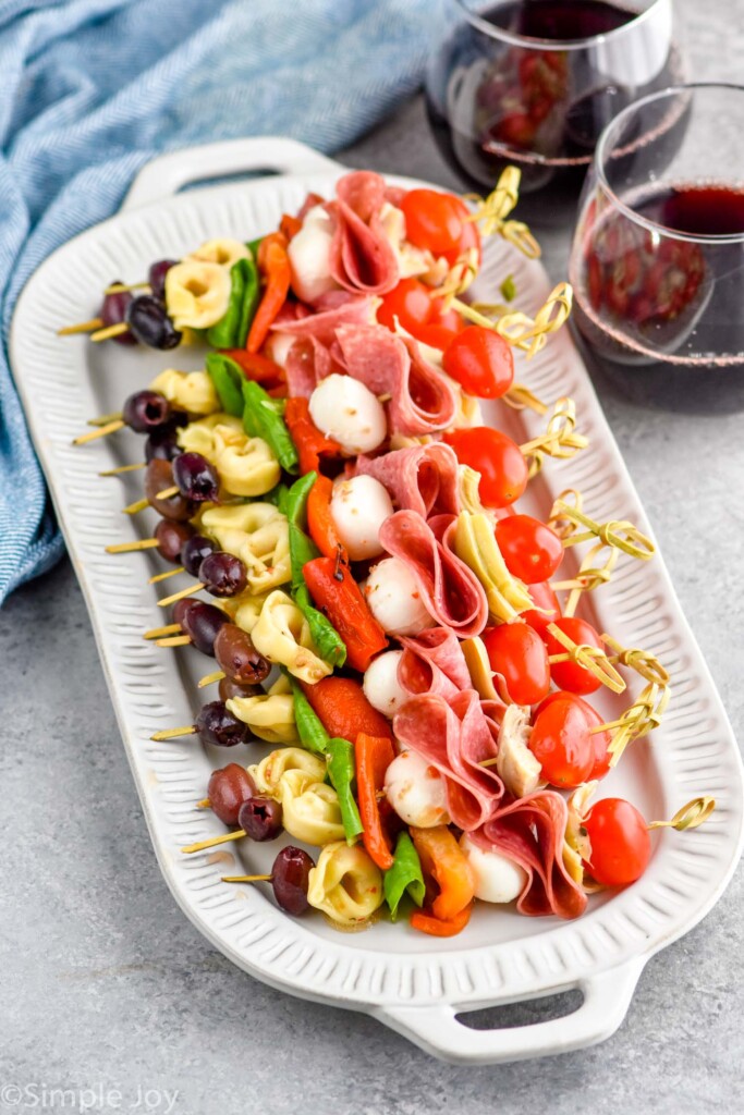 platter of Antipasto Skewers with two glasses of red wine sitting behind