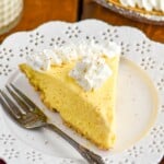 Piece of Eggnog Pie on a plate topped with whipped cream and a fork sitting beside