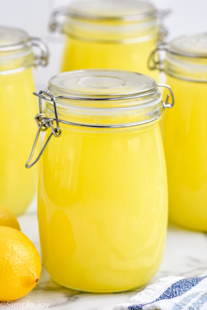 Jars of Limoncello with lemons beside.