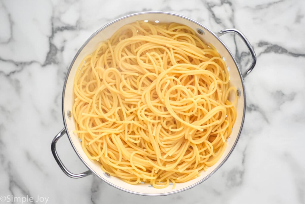 overhead of colander of cooked spaghetti noodles