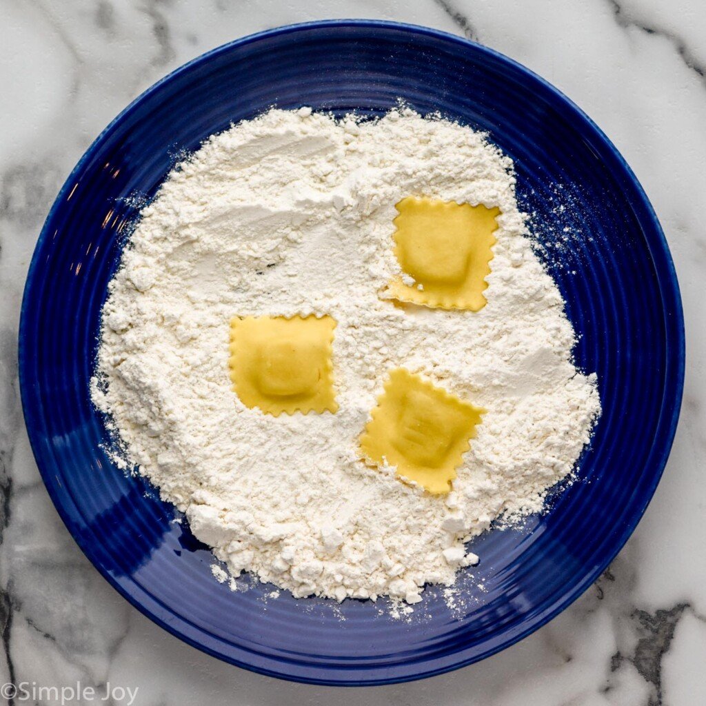 plate of flour with three ravioli on top to make Fried Ravioli