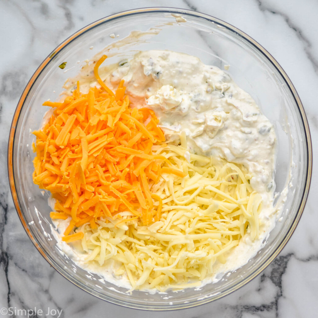 overhead of bowl of shredded cheese and Jalapeño Popper Dip ingredients