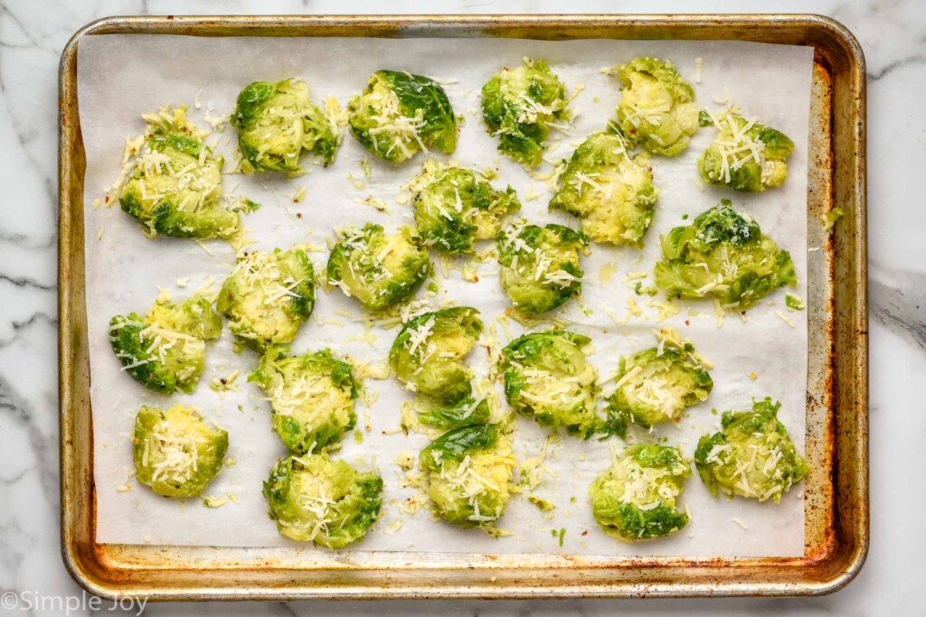 Overhead view of parchment-lined baking sheet with Smashed Brussel Sprouts recipe before baking.