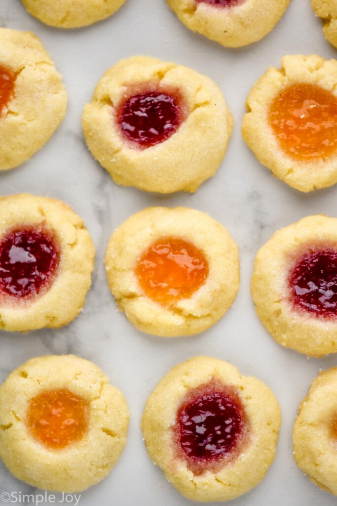 Overhead view of Thumbprint Cookies filled with two different colors of jam set out on countertop.