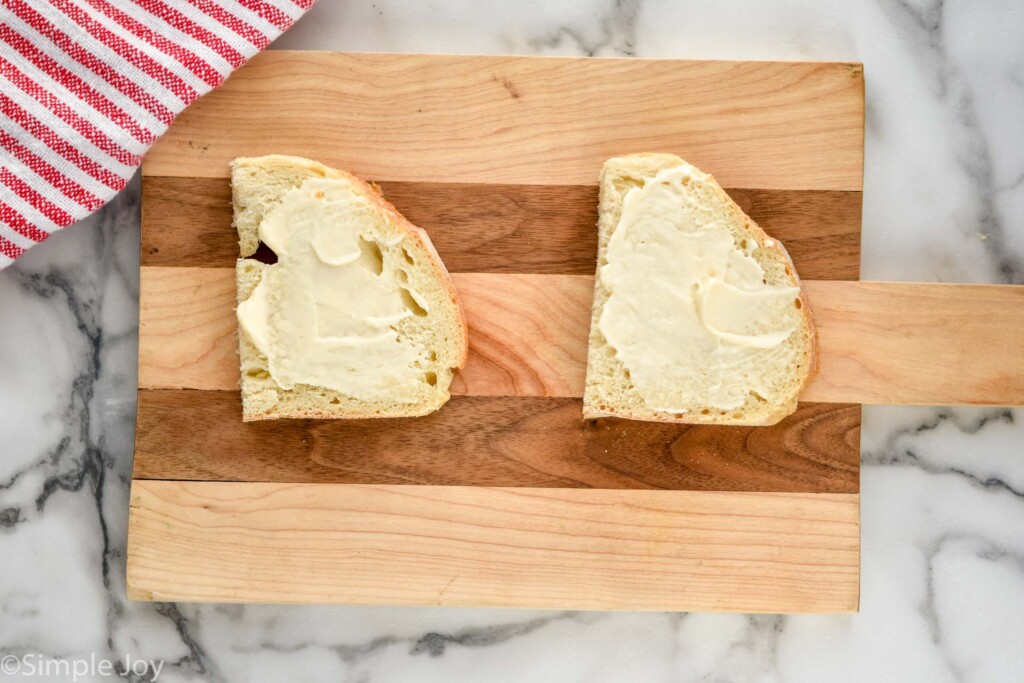 overhead of sourdough bread with mayo on a wooden cutting board to make a meatloaf sandwich