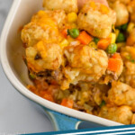 Pinterest graphic for tater tot casserole. Image shows wooden spoon holding tater tot casserole out of baking dish. Says "tater tot casserole simplejoy.com"