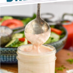 Pinterest graphic for Thousand Island Dressing recipe. Text says, "the best Thousand Island Dressing simplejoy.com." Image shows a jar of Thousand Island Dressing with a spoon getting some Thousand Island Dressing off the top. Salad with tongs behind.