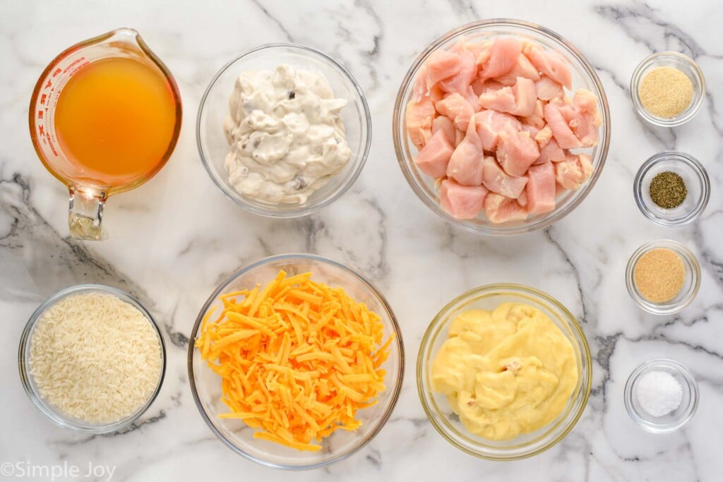 Overhead view of ingredients for Chicken and Rice Casserole recipe in glass bowls on countertop.