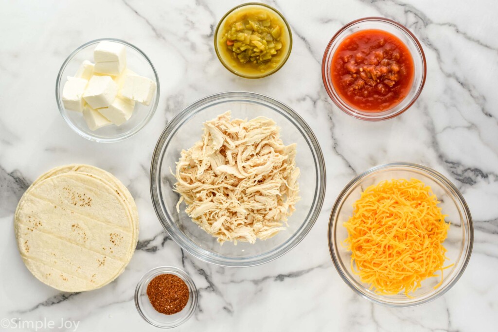 Overhead view of glass bowls of ingredients and tortillas on counter for Chicken Taquitos recipe.