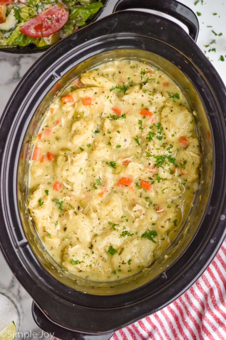 Overhead view of crock pot of Crockpot Chicken and Dumplings recipe with salad beside