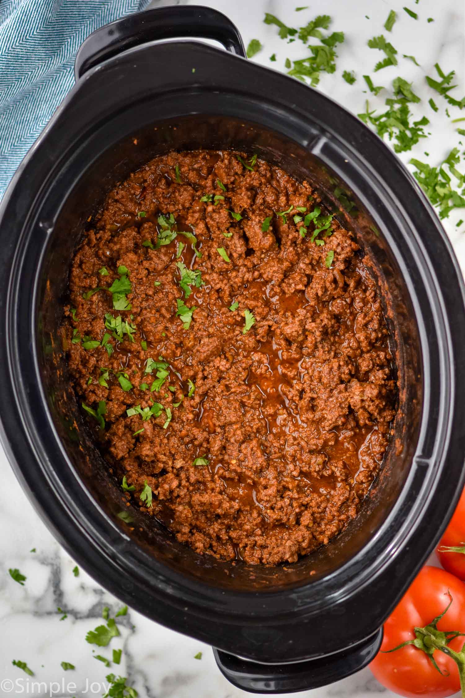 Overhead view of Slow Cooker Taco Meat in a crock pot garnished with cilantro