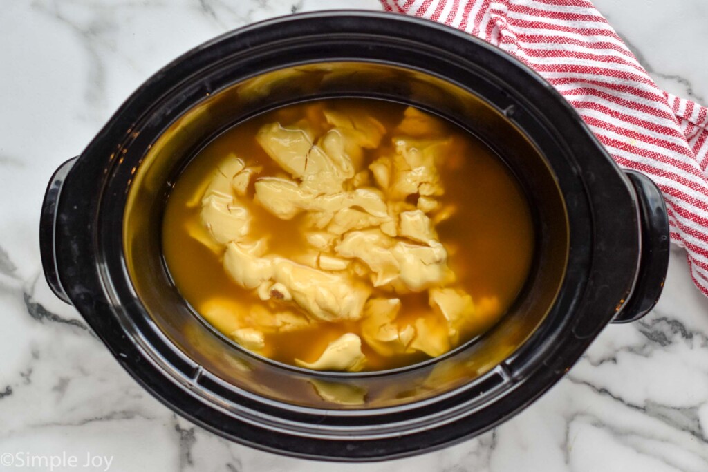 Overhead view of crock pot with ingredients for Crockpot Chicken and Dumplings recipe