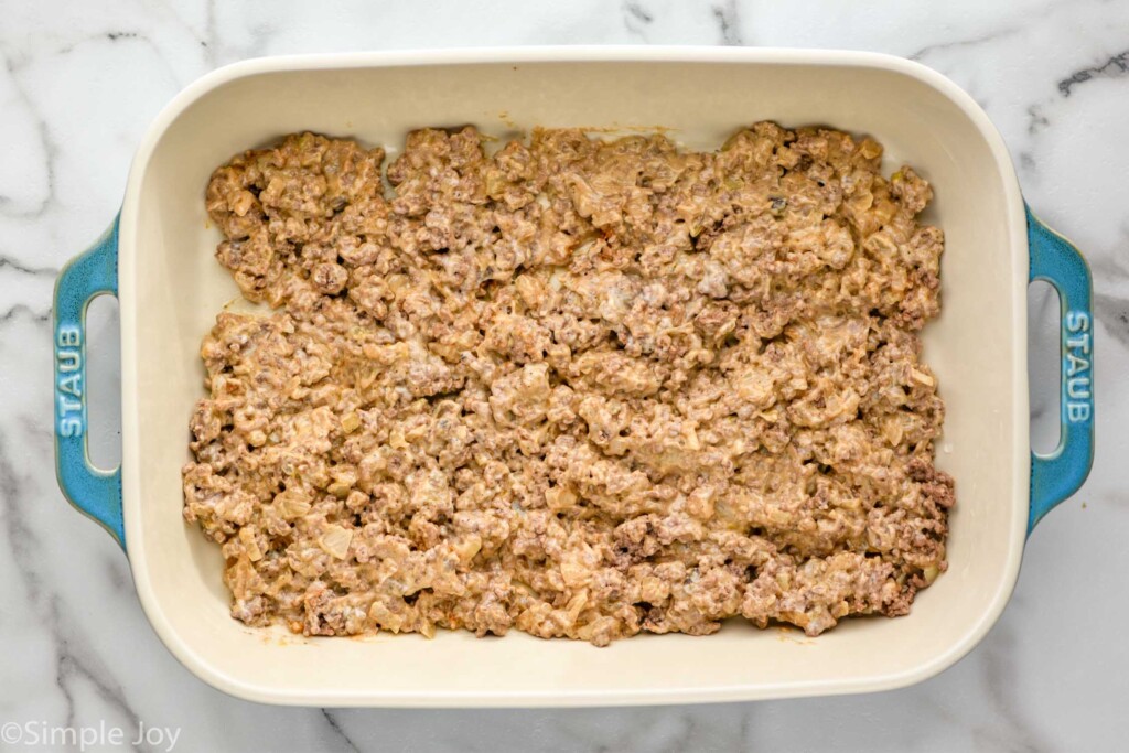 Overhead of baking dish of ground beef mixture to make tater tot casserole