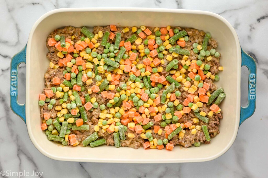 Overhead of baking dish of layered tater tot casserole ingredients