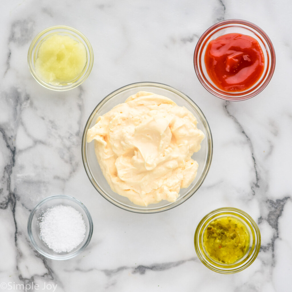 Overhead view of clear bowls of ingredients for Thousand Island Dressing recipe on a countertop.