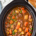 Pinterest graphic for Crockpot Beef Stew recipe. Text says, "the best crockpot beef stew simplejoy.com." Image is overhead view of a slow cooker of Crockpot Beef Stew.