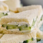 Pinterest graphic for cucumber sandwich. Text says "the best cucumber sandwich simplejoy.com" Image shows close up of a stack of cucumber sandwiches on a plate.