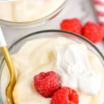 Pinterest graphic for Pudding recipe. Text says, "the best Pudding simplejoy.com." Image shows a bowl of Pudding garnished with raspberries and whipped cream, with a spoon. Raspberries beside.