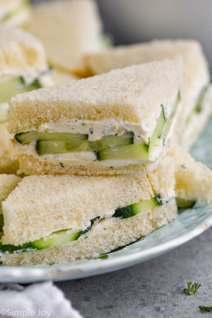 close up of stack of cucumber sandwiches on a plate