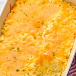 Overhead view of a baking dish of hashbrown casserole with one serving removed