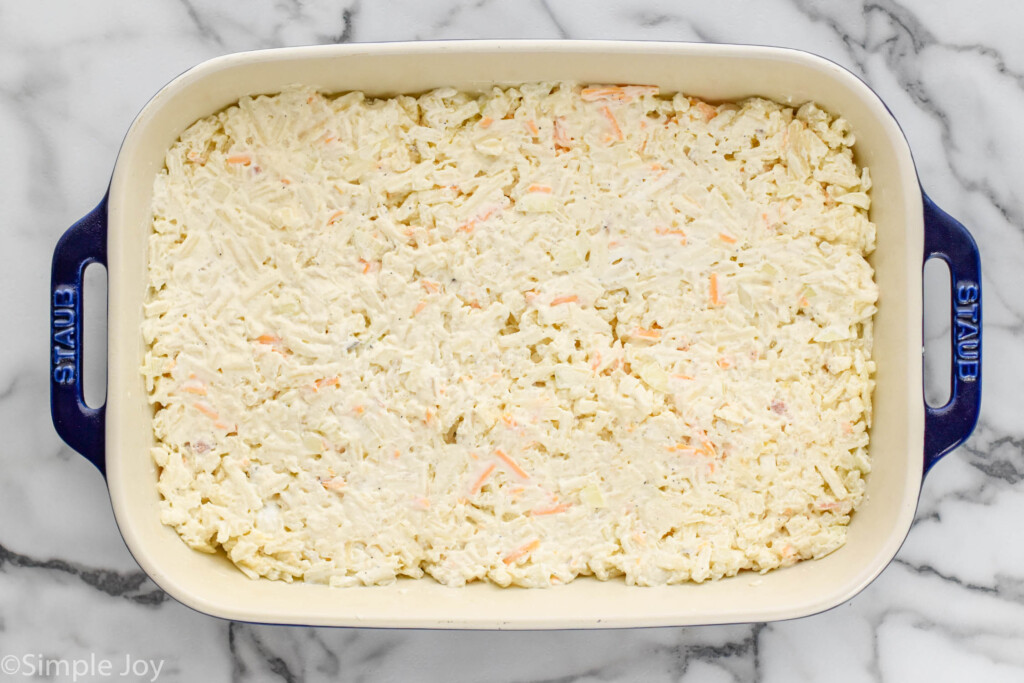 Overhead view of a baking dish with ingredients for hashbrown casserole recipe