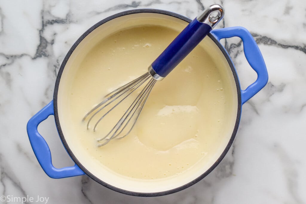 Overhead view of a pot of Pudding recipe with a whisk