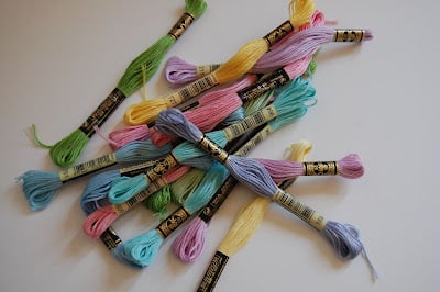 a pile of different pastel color embroidery floss skeins