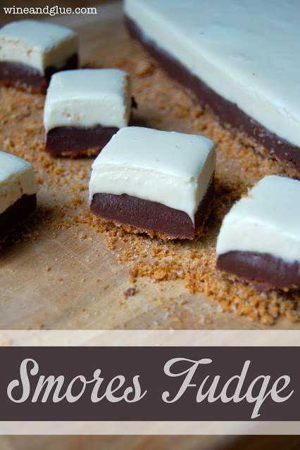 S'mores Fudge with a graham cracker crust and delicious marshmallow fudge topping sandwiching a delicious chocolate fudge! 