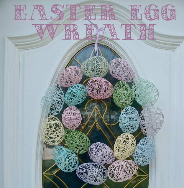 An Easter Egg Wreath made with embroidery floss eggs hanging on a door.