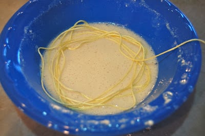 a small blow bowl with a mixture of flour and sea-flo in it, a piece of yellow embroidery floss, being added in careful circles.